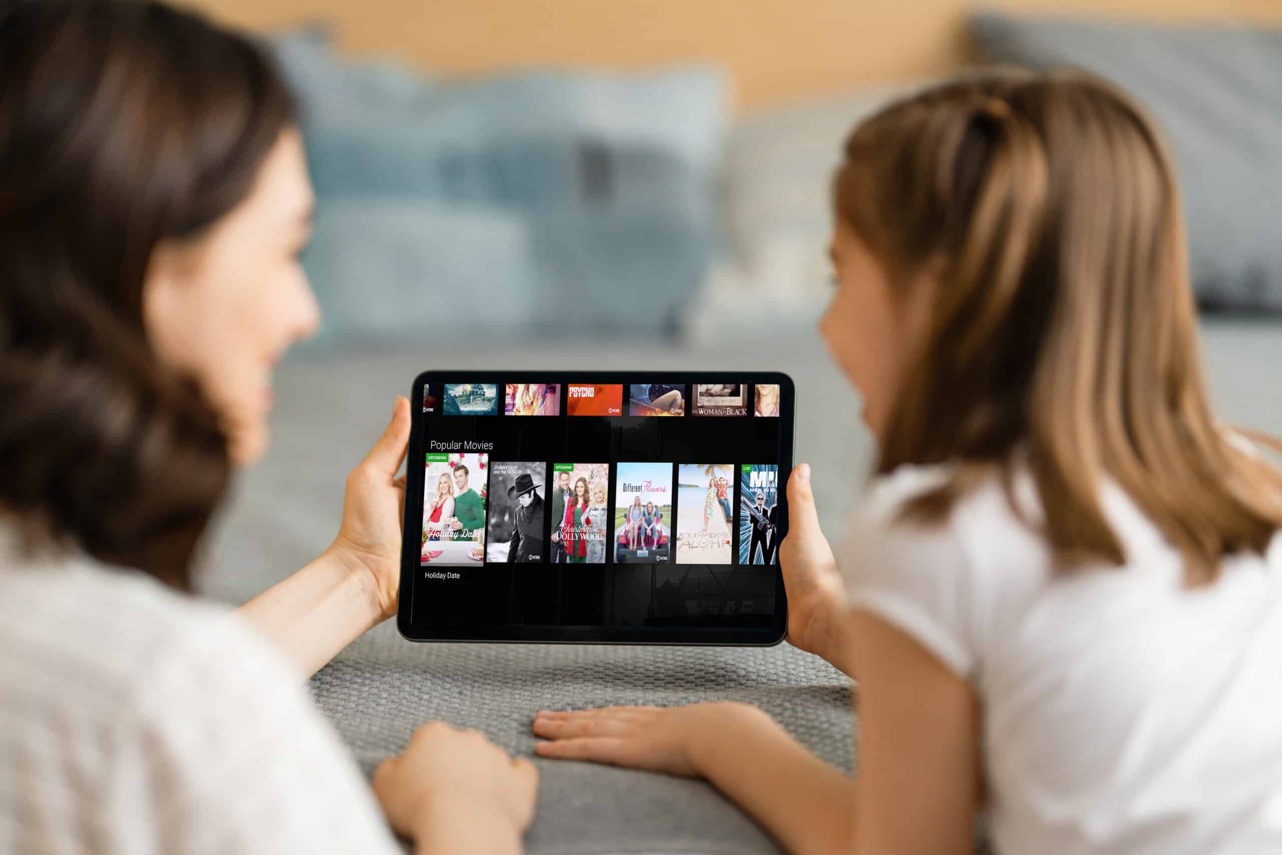 Happy loving family. Young mother and daughter girl using tablet pc for remote conversation with grandma. Funny mom and lovely child are having fun staying at home.